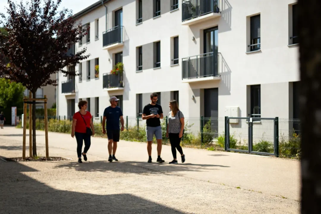 Groupe de personnes marchant devant un bâtiment résidentiel moderne affilié à Ophis