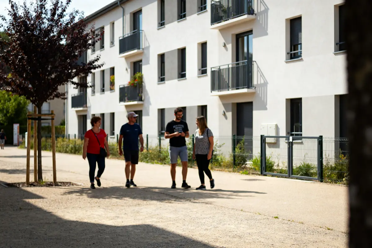 Groupe de personnes marchant devant un bâtiment résidentiel moderne affilié à Ophis