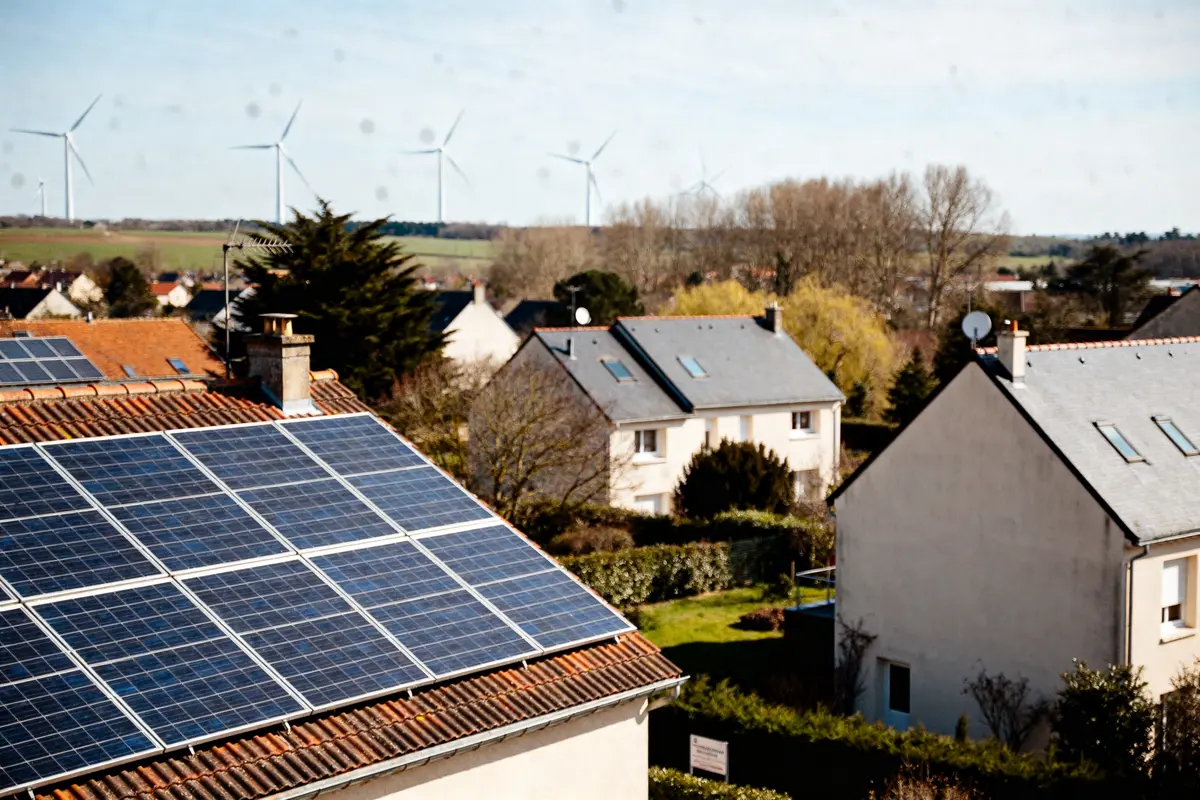 Maisons avec panneaux solaires et éoliennes à l'horizon produisant une co valence énergie renouvelable