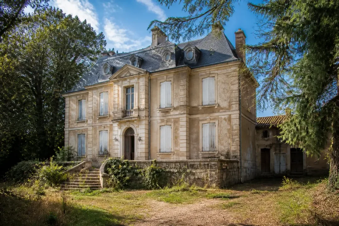 Façade ancienne d'un manoir entouré de végétation chez Maison Ethier