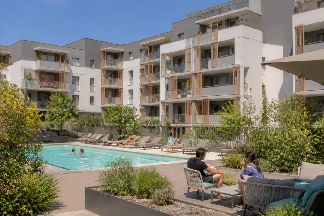 Piscine extérieure entourée de jardins et d'un bâtiment moderne de condos élégants